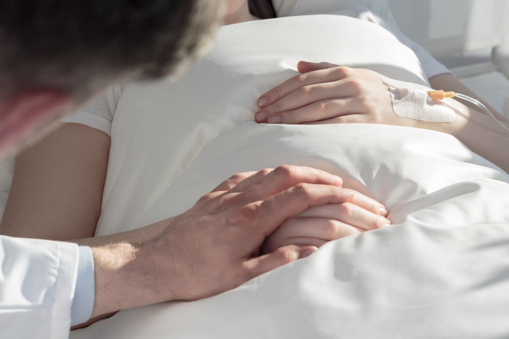 holding hand of a patient with serious illness