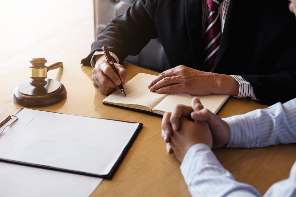 a lawyer taking notes while talking to businessman