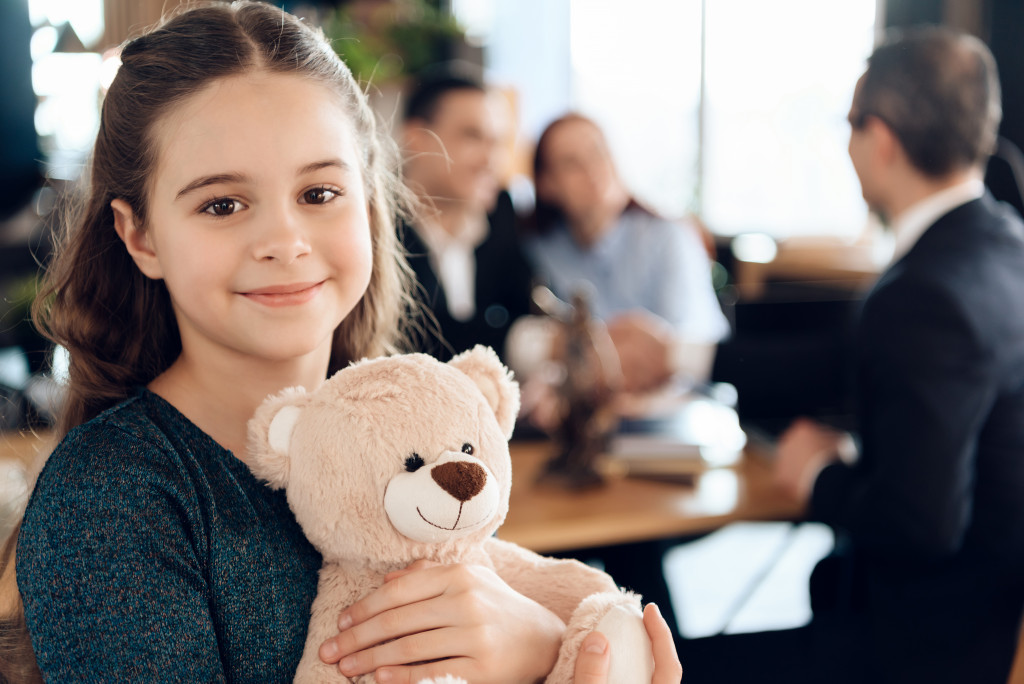 little girl hugging teddy bear in lawyer's office