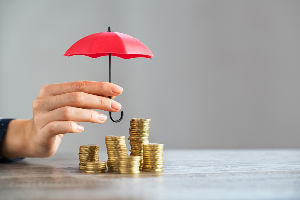 Business woman with umbrella and coins